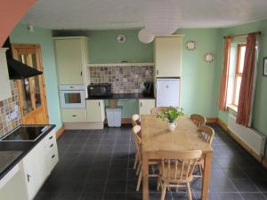 a kitchen with a wooden table and a dining room at Gorteen in Caherdaniel