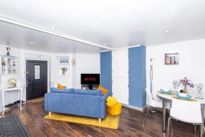 a living room with a blue couch and a table at Exclusive Apartment - close to centre, contactless entry, free parking, WiFi & Netflix in Leeds