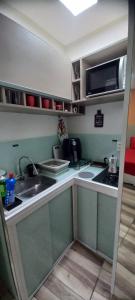 a small kitchen with a sink and a microwave at Loft Portal Beach 01 in Recife