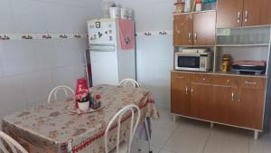 a small kitchen with a table and a refrigerator at Recanto do Ze Bonito in Conde