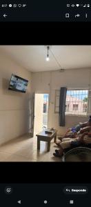 two people laying on a couch in a living room at Alojamiento Artigas in Artigas