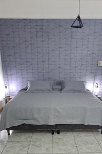 a bedroom with a large bed with a wall at Monoambiente Eldorado II in Eldorado