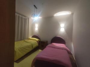 two beds in a room with lights on the wall at شقة فندقية قريبة من المتحف المصرى ومول مصر والاهرامات عجائب الدنيا السبعة in Cairo