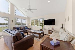 a living room with a couch and a tv at Expansive Lakefront Home with Private Dock in Grand Junction