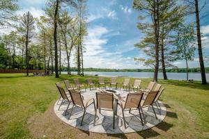 a round table with chairs and a lake in the background at Expansive Lakefront Home with Private Dock in Grand Junction