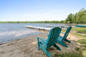 2 chaises bleues assises sur la rive d'un lac dans l'établissement Dog-Friendly Cozy Home with Hot Tub and Lake Access, à Grand Junction