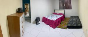 a bedroom with a bed and a dresser in a room at Apto 1 quarto mobiliado in São Mateus