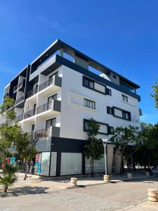 a tall white building with a lot of windows at Penthouse cerca de la playa in Tulum