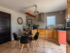 a kitchen with a table and chairs and a clock at DUXCAAR Saint Pabu Comfortable holiday residence in Saint-Pabu +32 photos