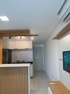 cocina con armarios blancos y encimera en una habitación en Loft em Armação, Centro de convenções, en Salvador