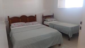 two beds in a room with white walls at Recanto do Ze Bonito in Conde