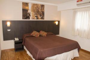 a bedroom with a bed and a picture on the wall at Hotel Zurich in Rosario +15 photos