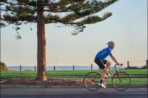 a man riding a bike down a street at Classy Spaces Keysborough - New 2 Storey Townhouse in Keysborough