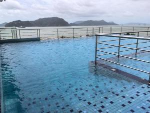 a large pool of blue water next to a body of water at Soft Langkawi 09 in Kuah