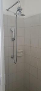 a shower with a shower head in a bathroom at Hostal Mari sabina in Bucerías +22 photos