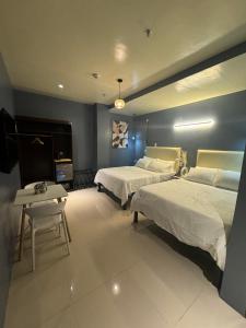 a large bedroom with two beds and a table at IAO Boutique Hotel in Dapa