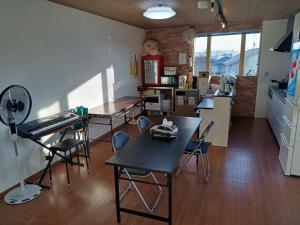 a room with tables and chairs and a kitchen at Guest House Ihatov - Vacation STAY 33059v in Takamatsu +8 photos