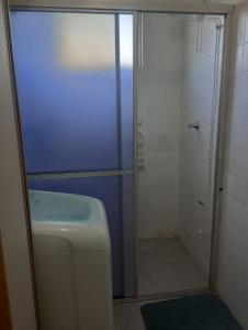 une salle de bain avec une douche avec des toilettes et un lavabo dans l'établissement Ap a 80m Praia Central de Barra Velha, à Barra Velha 3 autres photos