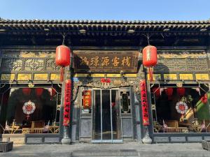 平遥Pingyao HongJingYuanGuesthouse的前面有红色灯笼的建筑