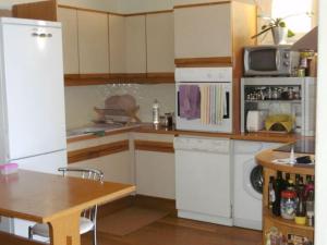 een keuken met witte kasten, een tafel en een koelkast bij Beausoleil Monaco Comfortable holiday residence in Beausoleil