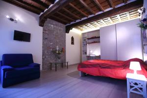 フィレンツェにあるVisit Florentia Apartmentのベッドルーム(赤いベッド1台、青い椅子付)