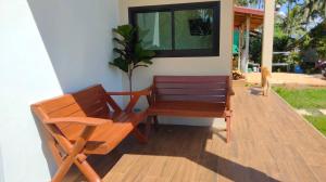 a wooden bench sitting on a porch with a cat at A Garden in Ban Dan Kao