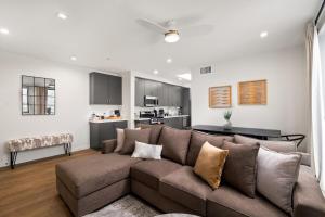 a living room with a brown couch and a kitchen at King Bed EVCharger Sleeps 8 Balcony Laundry in San Diego
