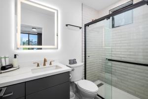 a bathroom with a toilet and a sink and a shower at King Bed EVCharger Sleeps 8 Balcony Laundry in San Diego +26 photos