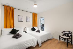 a bedroom with two beds and a chair at King Bed EVCharger Sleeps 8 Balcony Laundry in San Diego