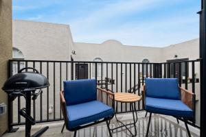 two chairs and a table and a grill on a balcony at King Bed EVCharger Sleeps 8 Balcony Laundry in San Diego