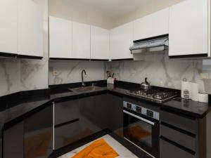 a kitchen with white cabinets and a sink and a stove at Vista bella luxurious apartment in Martil