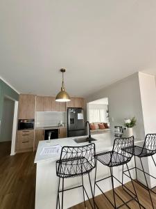 a kitchen with a table and four chairs in a room at Cosy 3 Bedroom Home near airport with free parking in Auckland
