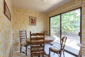 a dining room with a table and chairs and a window at The Forest Knook in Pebble Beach in Del Monte Forest