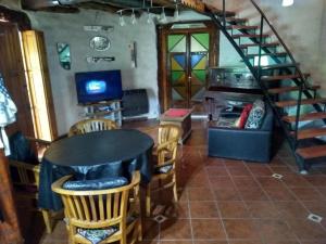 a living room with a table and chairs and a staircase at Casa Tika, in La Consulta