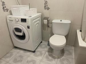 un bagno con WC e lavatrice di Acogedora planta baja a Benaguacil Altre 39 foto