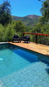 Dos sillas sentadas en una terraza junto a una piscina. en Refugio del Valle, en La Falda