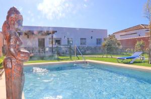 una estatua de una mujer parada junto a una piscina en Casa Nispero, en Conil de la Frontera 25 fotos más