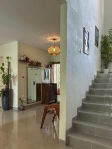 a living room with a staircase in a house at Cozy Botanical Garden House in Batam Center