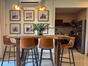 a kitchen with a wooden table with four bar stools at Cozy Botanical Garden House in Batam Center +35 photos