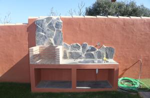 pared de piedra con fregadero en un patio en Casa Nispero, en Conil de la Frontera