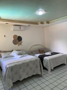 a room with two beds in a room at Pousada Elizondo in Natal