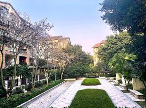 a garden with a walkway between two buildings at 哲帆民宿 大竹林龙湖江与城花园洋房店 in Chongqing