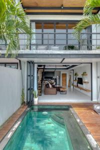 a house with a swimming pool and a living room at Echo Haven A2 1BR Loft In Canggu in Canggu