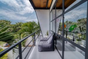 a balcony with a couch and a mural on the wall at Echo Haven A2 1BR Loft In Canggu in Canggu