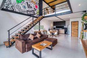 a living room with a couch and a staircase at Echo Haven A2 1BR Loft In Canggu in Canggu