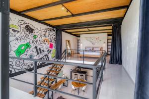 a bedroom with a wall with graffiti on it at Echo Haven A2 1BR Loft In Canggu in Canggu +32 photos