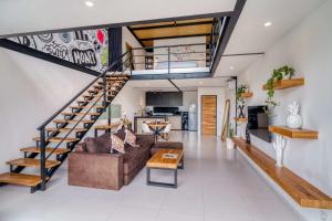 a living room with a couch and a staircase at Echo Haven A2 1BR Loft In Canggu in Canggu