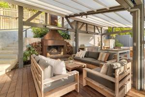 a patio with a couch and a fireplace at GARRATT VIEW - Coast & Country in Waiheke Island