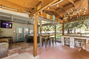 a patio with a bar with a table and chairs at the Hot Tub Farmhouse in Canyon Lake