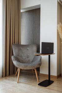 a chair sitting next to a desk with a laptop at Dosoftei Residence in Chişinău